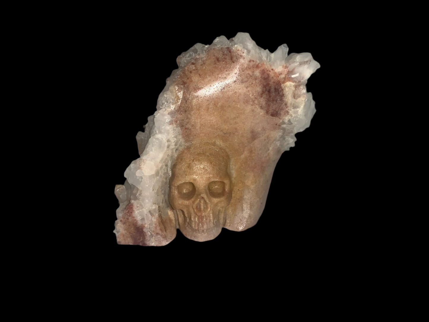 Clúster de cuarzo con calavera de sanador dorada tallada sobre matriz